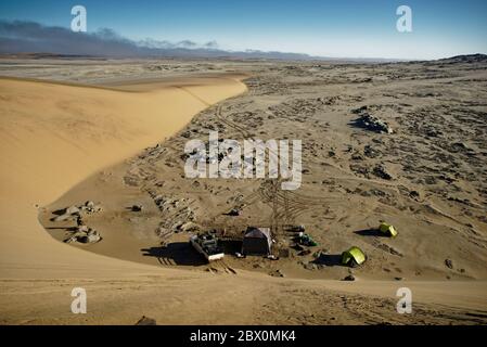 Impostazione del campo visto dalla cima di una duna di sabbia. Safari nel deserto con quattro ruote motrici sulla Skeleton Coast della Namibia, Africa sud-occidentale. Foto Stock