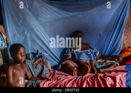 Lagos, Nigeria. Una donna e i suoi due figli nella loro nuova casa che è condiviso con altre tre famiglie in Sogunru in Yaba area di Lagos. Più di anno dopo la sentenza della Corte di giustizia, il Lagos il Governo statale è ancora a stabilirsi o a compensare gli sfollati di Otodo Gbame. Foto Stock