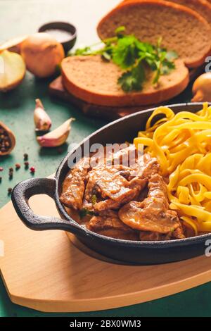 Gustoso stroganoff di manzo con pasta sul tavolo Foto Stock