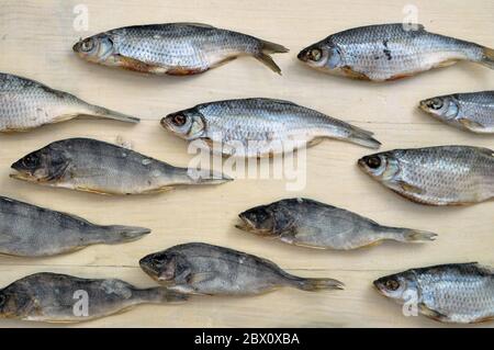 Fiancheggiata pesce secco modello su una superficie di legno. Tessuto di fondo del prodotto di pesce secco. Foto Stock