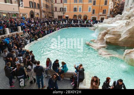 Roma, Italia - 13 febbraio 2016: I turisti si trovano vicino alla Fontana di Trevi, simbolo iconico della Roma Imperiale Foto Stock