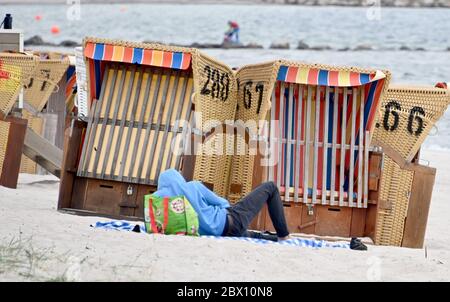 04 giugno 2020, Schleswig-Holstein, Eckernförde: Un ospite balneare si trova sulla spiaggia del Mar Baltico, accanto a sedie a sdraio chiuse. Foto: Carsten Rehder/dpa Foto Stock