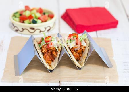 Due tacos vegan trainati con jackfruit realizzati con tortillas di mais morbido in un supporto per tortilla. Foto Stock