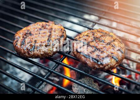 carne di hamburger di manzo che cucinano su grill al carbone all'aperto Foto Stock