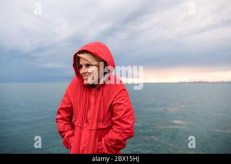 Giovane donna in piedi all'aperto sulla spiaggia al tramonto. Spazio di copia. Foto Stock
