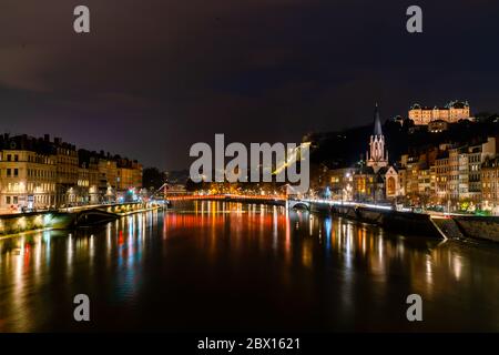 Lione, Francia 3 gennaio 2020 - persone che srosano il fiume Saone sul ponte Passarelle St. Georges (passerella Saint George) di notte Foto Stock