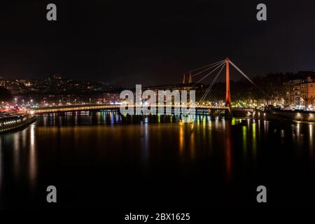 Lione, Francia 3 gennaio 2020 - persone che di notte si srosano il fiume Saone sul ponte Passerelle du Palais de Justice (Law Courts Walkway) Foto Stock