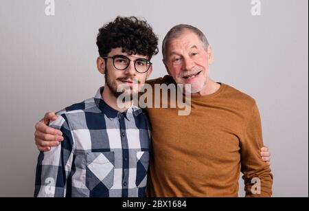 Ritratto di un giovane e un padre anziano allegro in studio, guardando la macchina fotografica. Foto Stock