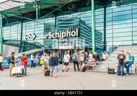 I passeggeri che entrano e escono dall'edificio principale dell'aeroporto Schiphol di Amsterdam Foto Stock