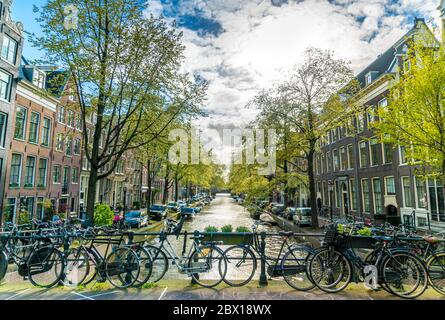 Amsterdam, Paesi Bassi, 22 aprile 2017: Piccolo e tranquillo canale con biciclette sul ponte di fronte al centro di Amsterdam Foto Stock