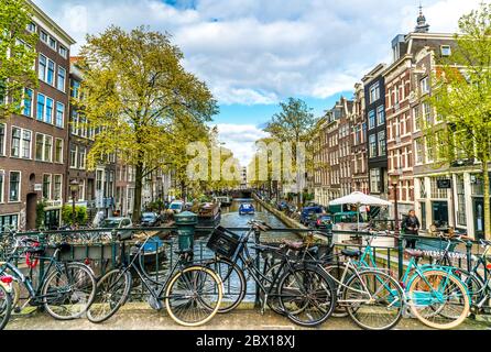 Amsterdam, Paesi Bassi, 22 aprile 2017: Piccolo e tranquillo canale con biciclette sul ponte di fronte al centro di Amsterdam Foto Stock