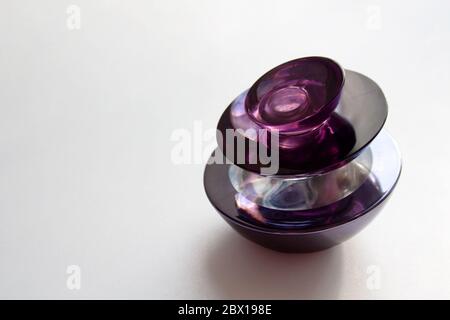 Flacone di profumo in vetro viola scuro isolato su sfondo bianco con uno spazio per la copia Foto Stock