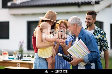 Ritratto di famiglia multigeneration all'aperto su barbecue giardino. Foto Stock