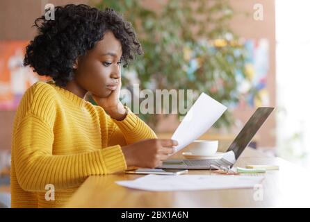 Donna imprenditore che lavora con documenti al caffè Foto Stock