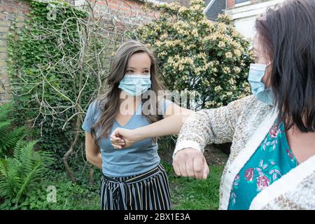 Saluto due donne in maschere protettive durante l'epidemia di virus. Foto Stock