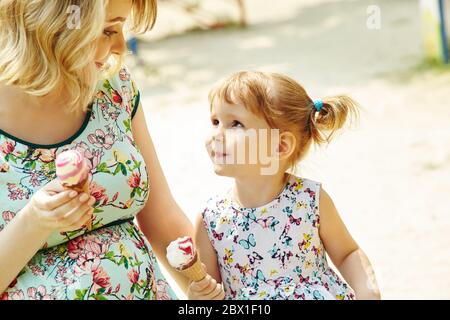 Mamma e bambino mangiano gelato, madre e figlia all'aperto. Foto Stock