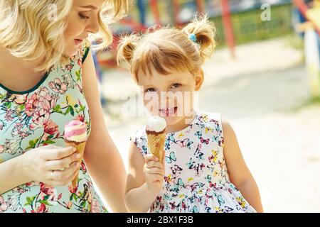 Mamma e bambino mangiano gelato, madre e figlia all'aperto. Foto Stock