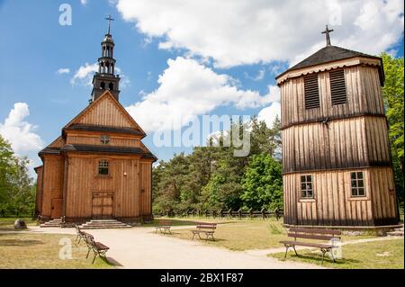 Museo del Villaggio Mazovian in Sierpc, Polonia. Tradizionale chiesa di legno circondato da alberi e nuvoloso, cielo blu Foto Stock