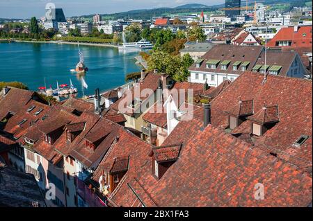 Zug, Svizzera - Settembre 2016: Vista dalla torre dell'orologio Zytturm attraverso la città vecchia medievale e il lago Zug. Tetti rossi lungo il lungolago Foto Stock