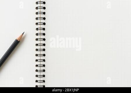 Primo piano di un notebook a spirale vuoto e di una matita. Foto Stock