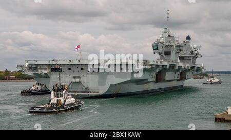 La Royal Navy Aircraft carrier HMS Queen Elizabeth (R08) ritornò a Portsmouth, Regno Unito il 4 giugno 2020 per imbarcarsi con il personale di 617 Squadron (i Dambuster) insieme alle loro attrezzature per sostenere un'ala aerea di F-35B Lightning II. La nave salpa e guiderà un gruppo di sciopero di portaerei in un esercizio chiamato Crimson Ocean. L'aeromobile F-35B e gli elicotteri che lo accompagnano probabilmente si uniranno alla nave una volta che sarà di nuovo in mare. Foto Stock