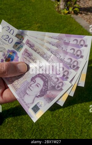 Primo piano di Man Person Hand con nuove banconote inglesi da 20 sterline banconote in contanti Inghilterra Regno Unito Gran Bretagna Foto Stock