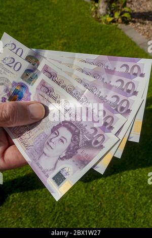 Primo piano di uomo persona mano che tiene inglese 20 20 sterline banconote banconote banconote contanti Sterling Inghilterra Regno Unito Regno Unito Gran Bretagna Foto Stock