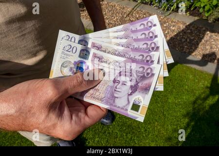 Primo piano dell'uomo persona che detiene il pagamento di nuove banconote da 20 libbre in contanti frode antiriciclaggio Inghilterra Regno Unito Regno Unito Gran Bretagna Foto Stock
