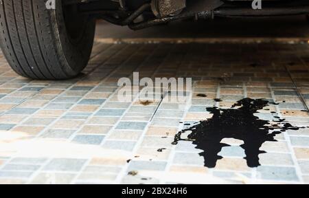 Perdite di olio o cadute dal motore dell'auto nel parcheggio. Servizio di ispezione e manutenzione auto Foto Stock