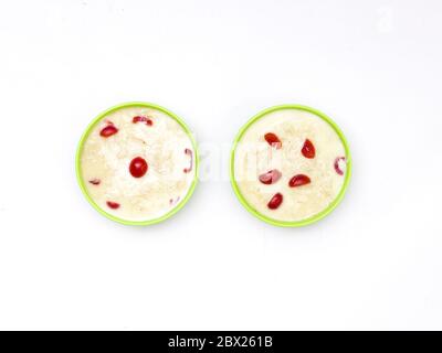 Sewai o kheer consumati in occasione di festival eid o indiani. Servito con condimenti di ciliegia rossa in una ciotola verde. Foto Stock