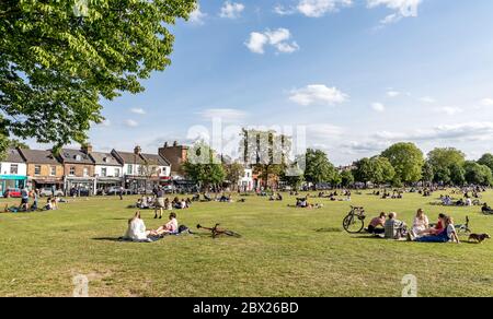 Chi si gode del sole primaverile a Wandsworth Common London UK Foto Stock