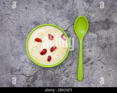 Sewai o kheer consumati in occasione di festival eid o indiani. Servito con condimenti di ciliegia rossa in una ciotola verde. Foto Stock