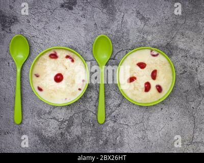 Sewai o kheer consumati in occasione di festival eid o indiani. Servito con condimenti di ciliegia rossa in una ciotola verde. Foto Stock