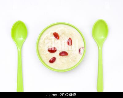 Sewai o kheer consumati in occasione di festival eid o indiani. Servito con condimenti di ciliegia rossa in una ciotola verde. Foto Stock