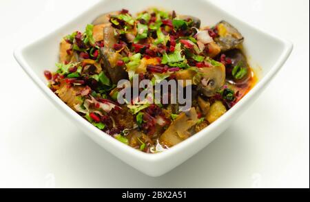 Un stufato di carne, patate, funghi e un mix di peperoni serviti in una ciotola bianca, pasto delizioso Foto Stock