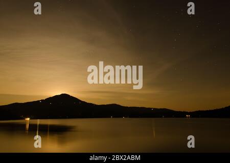 Luna aumento con stelle, nuvole, e montagne al Lago Burton, Georgia. Foto Stock