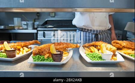 Pesce e patatine preparate in cucina commerciale nel Regno Unito Foto Stock