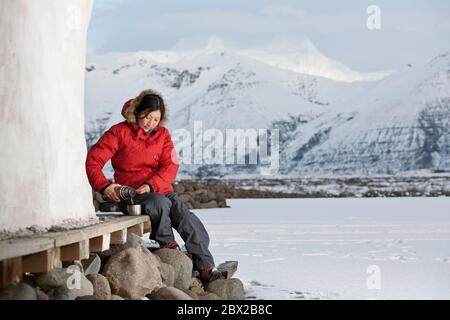 donna che versa una bevanda calda dalla beuta termica Foto Stock