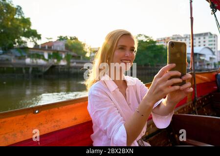 Una donna che visita da una lunga barca a coda a Bangkok Foto Stock