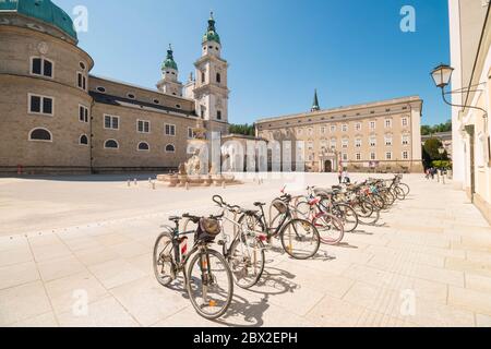 Salisburgo, Austria - 7 maggio 2020: Biciclette parcheggiate nella Residenzplatz, nella fontana Residenzbrunnen e nella cattedrale di Salisburgo sullo sfondo. Città vecchia di Foto Stock