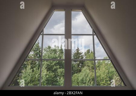 Vista interna della finestra a forma di trapezio attico - paesaggio idilliaco fuori dalla finestra - foresta e cielo Foto Stock