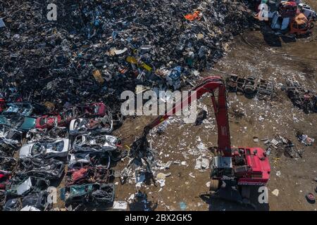 Vista aerea del cantiere. Vecchie auto arrugginite corrose nel cantiere. Settore del riciclaggio di automobili dall'alto. Foto Stock