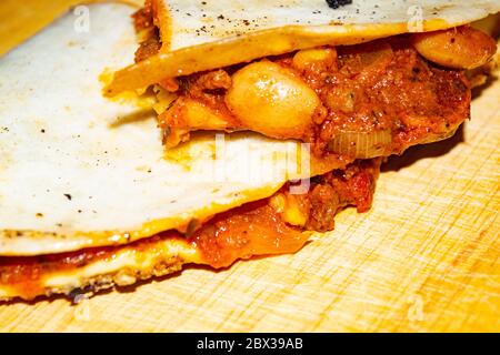 Quesadilla con manzo macinato, salsiccia, fagioli rossi, mais dolce, cipolla e salsa di pomodoro. Un pasto tradizionale messicano. Primo piano Foto Stock