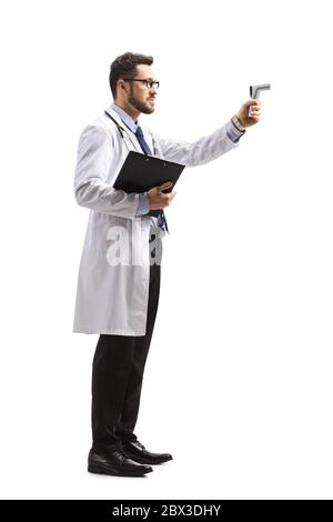 Immagine a profilo intero di un medico maschio che misura la temperatura con un termometro isolato su sfondo bianco Foto Stock