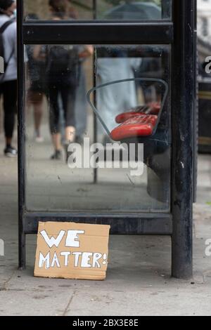 Un cartello di protesta abbandonato che si è appoggiato contro una fermata dell'autobus dopo la protesta Black Lives Matters a Londra, 3 giugno 2020 Foto Stock