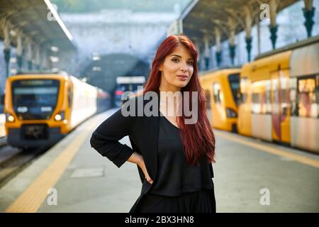 Una donna portoghese attende nella stazione ferroviaria di São Bento a Porto, in Portogallo Foto Stock