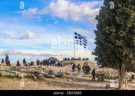 2018 01 03 Atene Grecia - i turisti all'Acropoli di Atene si riuniscono intorno alla bandiera greca scattando foto con la Cappella di San Giorgio su Lykavitto Foto Stock