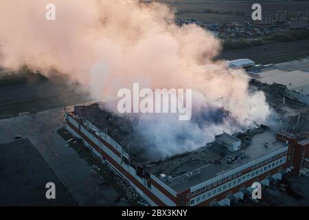 Vista aerea incendio con fumo in fabbrica industriale o in un altro edificio industriale. Foto Stock