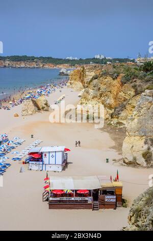 Vista sulla spiaggia di Praia da Rocha a Portimao con lettini, sedie a sdraio e ombrelloni in estate, Algarve occidentale, Portogallo meridionale Foto Stock