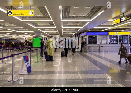 Piscina giallo luminoso segno di invito con un punto interrogativo e un cartello stradale su Airport e la stazione della metropolitana. Il passeggero in attesa sul punto di controllo Foto Stock
